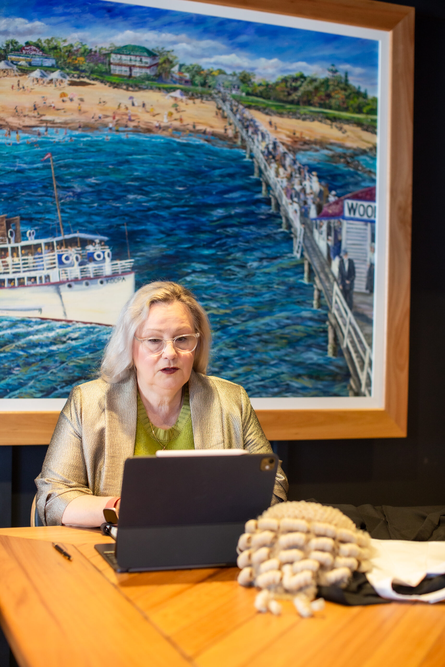 Sue-Ellen Wright sitting at a desk with court attire beside her, preparing legal material as a Queensland family law barrister.