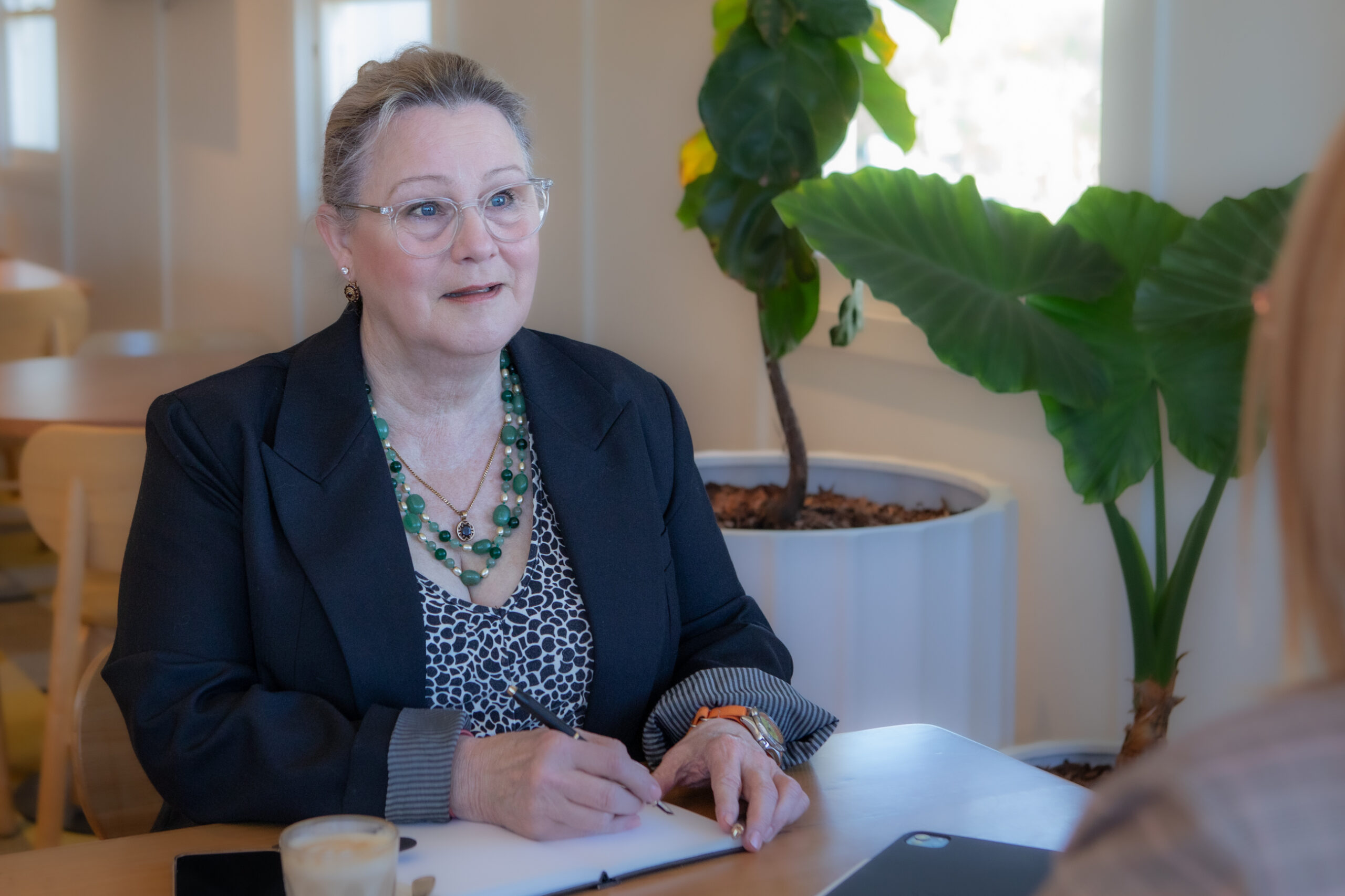 Sue-Ellen Wright writing notes while meeting with a client during a family mediation session in Queensland.